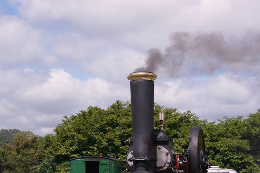 a shot of a smoking steam engine chimney against the skyline