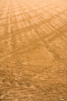 Prepared soil, waiting to be seeded. With tractor tracks.