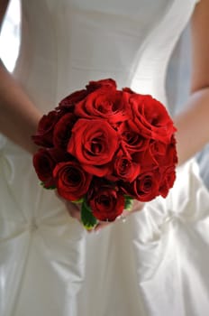 red rose bouquet in bride's hands