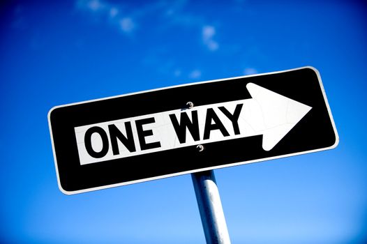 Image of a One Way Sign with blue sky