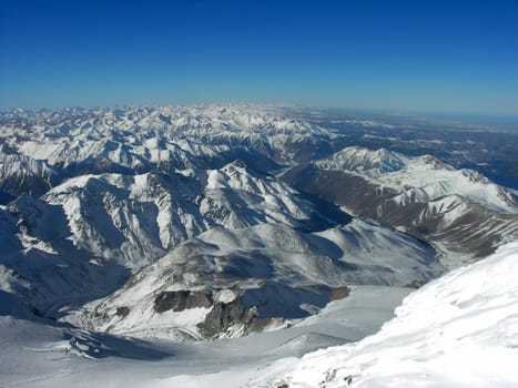  Snow-covered top of mountain on a background of the blue sky          