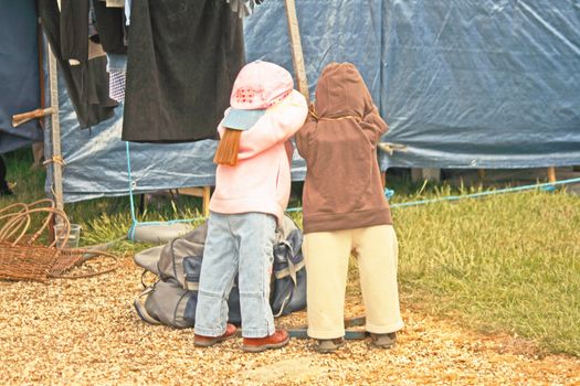 pair of clothes dummys made to look like two children playing hide and seek