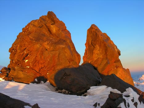 Two fragments of a red rock on a background of the blue sky
          