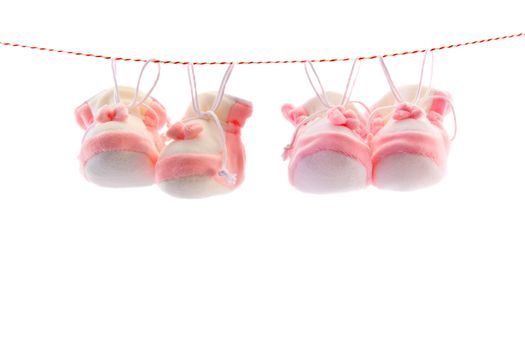 Two pairs of baby's slippers hanging on a rope. Including copy space.