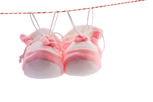 Pair of baby's slippers hanging on a rope. Including copy space.