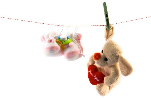 Slippers,soother and toy hanging on rope. Copy space.