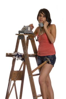 teenage girl standing on ladder talking on a old rotary phone with 