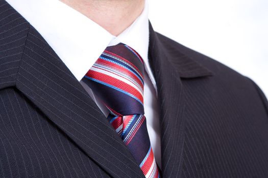 black fashion costume, cravat with red and blue stripes, and white shirt