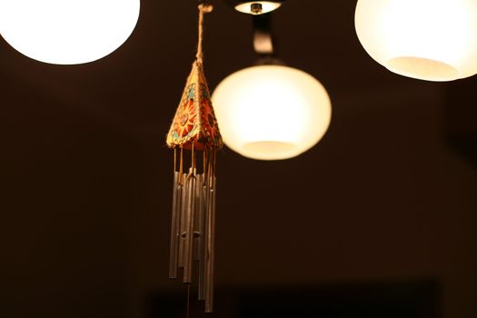 wind chimes and bright chandelier in dark room