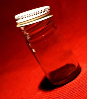 Glass Jar with white lid on red background