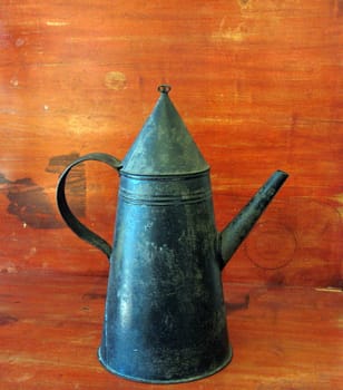 Antique tole coffee pot, sitting on a 19th century painted table