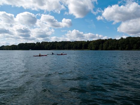 Men enjoying kayaking paddling kayaks on calm sea water