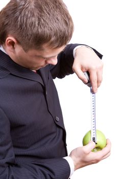 man is measuring the green apple by tape-measure