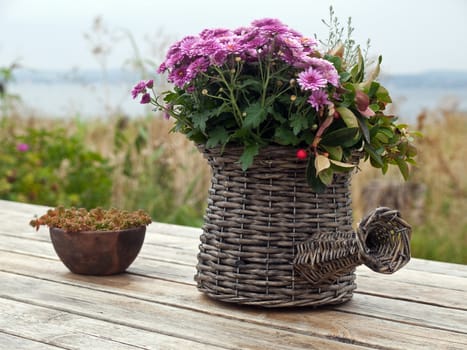 Beautiful still life basket of flowers on a wooden table 