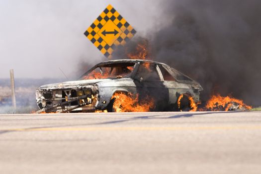 A car in flames on the roadside