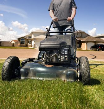 mowing the front lawn with houses in the background