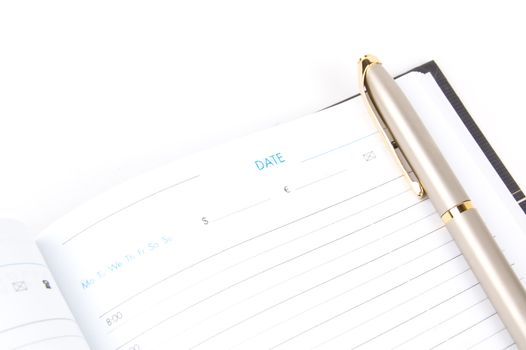 Appointment book and pen on a white background. Close-up. Macro.