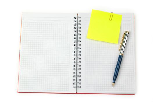 Yellow adhesive note and pen on a notebook. White background.