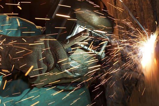 a welder working at shipyard under vessel