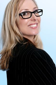 Smiling confident businesswoman wearing a suit glancing over her shoulder