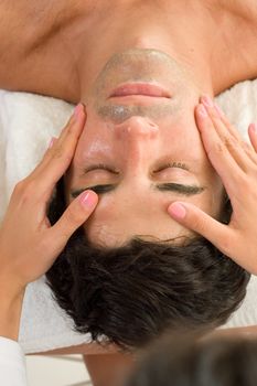 A male receives a facial treatment massage