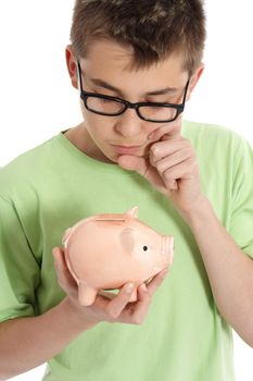 A boy holding a money box is thinking or pondering, eg finance, savings, spending.