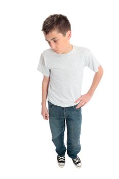 A boy standing in a plain t-shirt, blue jeans and sneakers.