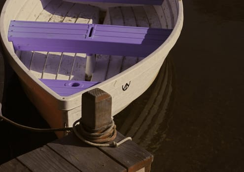 A small boat tied up to a personal dock.  Taken along the Venice canals in Los Angeles, California.