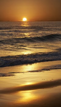 a picture of the sun over water and sand