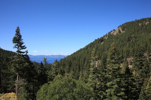 View of Lake Tahoe beyond mountain slope.