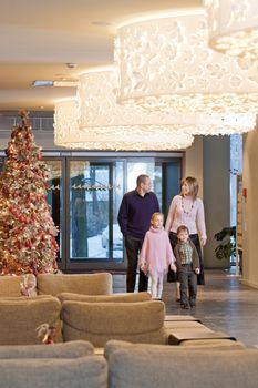 Happy family walking at foyer in the modern hotel