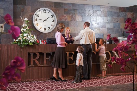 Happy family checking in at the reception desk 