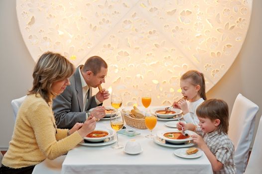 Happy family enjoying meal sitting at restaurant table