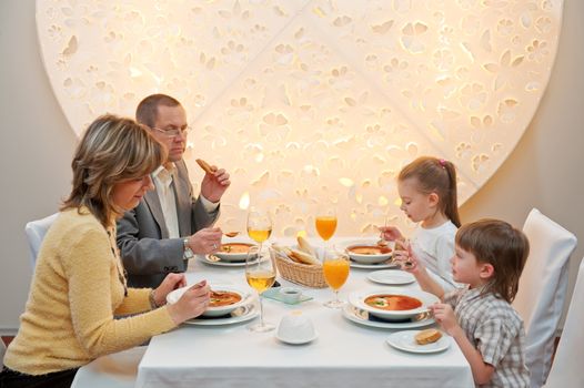 Happy family enjoying meal sitting at restaurant table