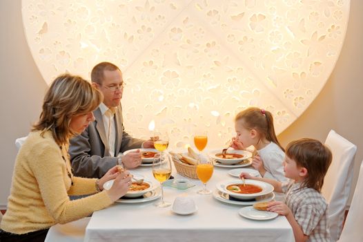 Happy family enjoying meal sitting at restaurant table