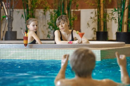 Happy attractive family relaxing by the pool