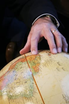 Business Man pointing to South America on Globe