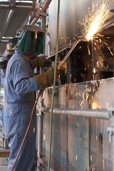 a worker using a torch to burn steel