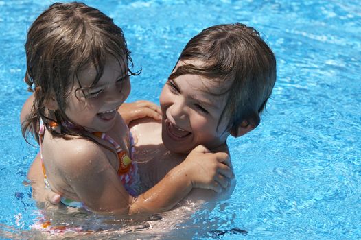 a brother and sister playing in a pool