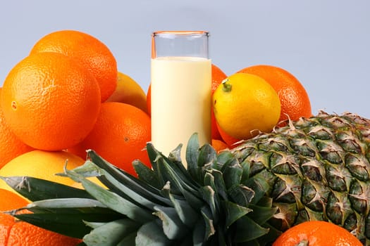 Fresh tropical fruit with juice and milk in a high glass glass.