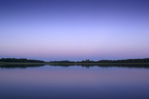 Lake view at dusk with peaceful water, Poland.