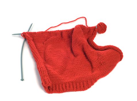 A sweate in the progress of being knitted, shot against a white background
