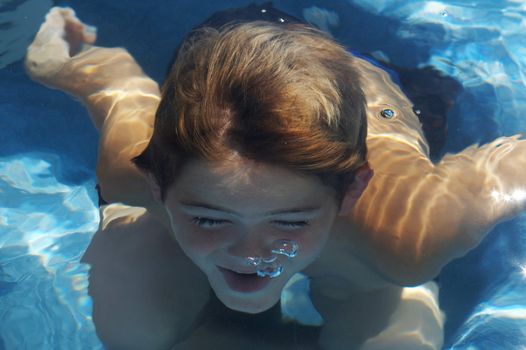 young boy underwater in pool