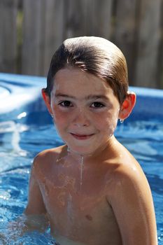 cute young boy in pool smiling