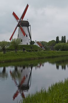 Windmill along canal with reflection in Damme Flanders