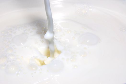 milk splashing into fresh milk with drops