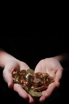 hands with money coins on a black background