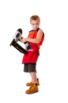 Cute kid with orange apron and yellow boots holding a heavy duty nail gun, isolated.