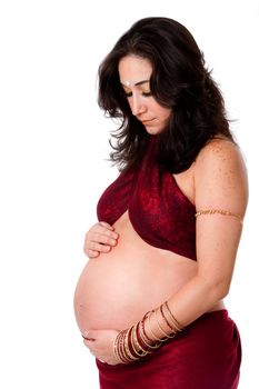 Beautiful pregnant woman dressed in red with bindi on forehead holding her belly and looking down, isolated