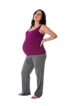 Beautiful pregnant Caucasian brunette woman holding her back with an uncomfortable expression. Pregnancy contraction back pains, isolated.